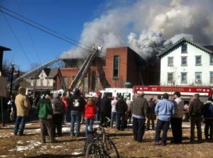 Spectators watch as the historic building, the Moose Exchange is up in flames